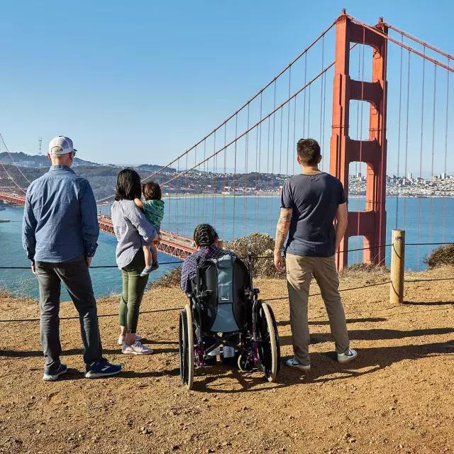 一群人, 包括一名轮椅使用者, 从后面看金门大桥从马林岬.